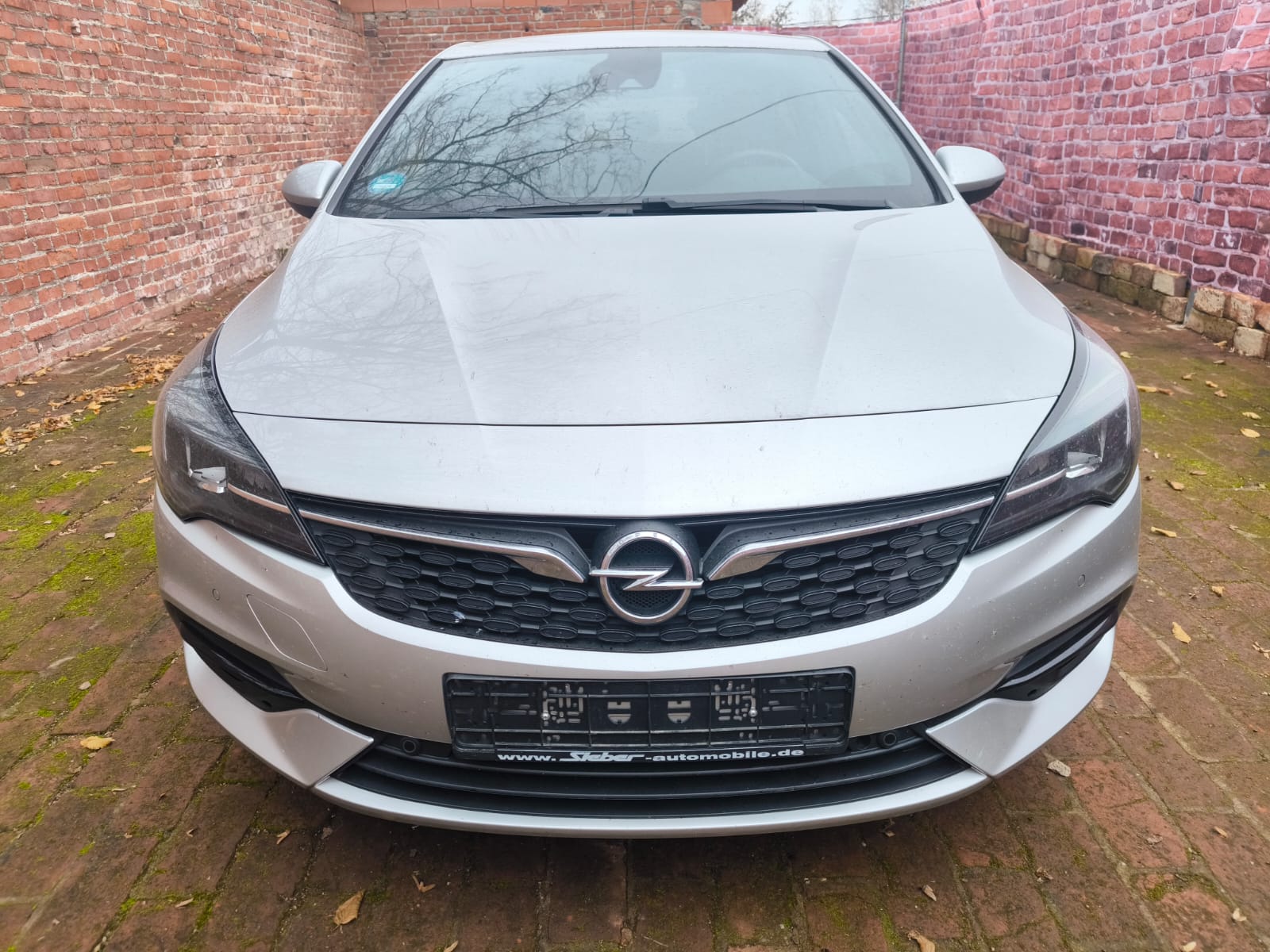 Opel Astra mit Getriebeschaden in Aachen verkaufen auf Innenhof vor Backsteinmauer