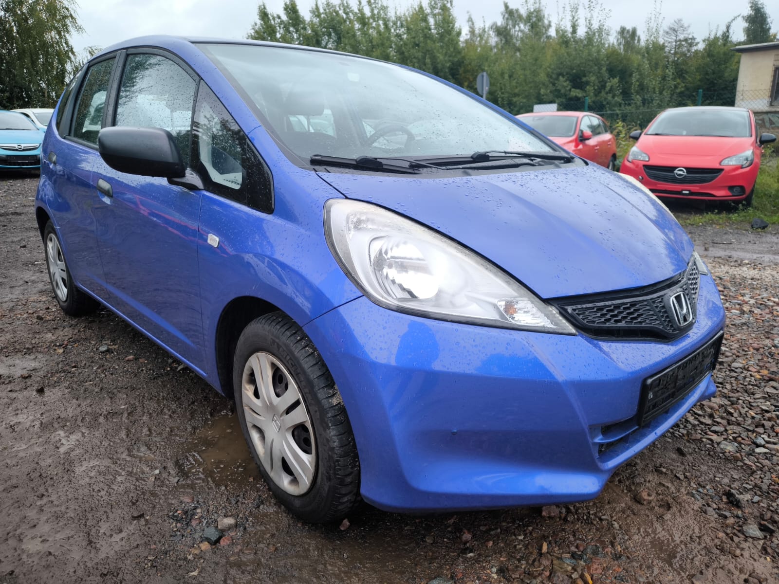 Honda Jazz in Blau nach erfolgreichem Autoverkauf in Aschaffenburg auf nassem Parkplatz