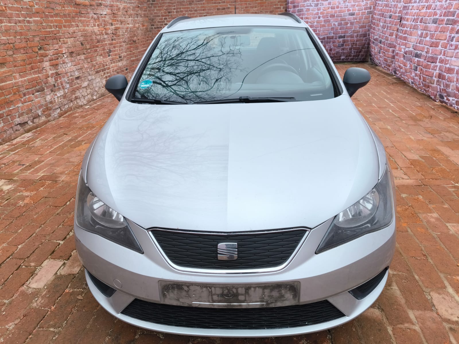 Silberner Seat Ibiza Kombi mit Motorschaden vor Backsteinmauer in Backnang verkauft an Autoankäufer