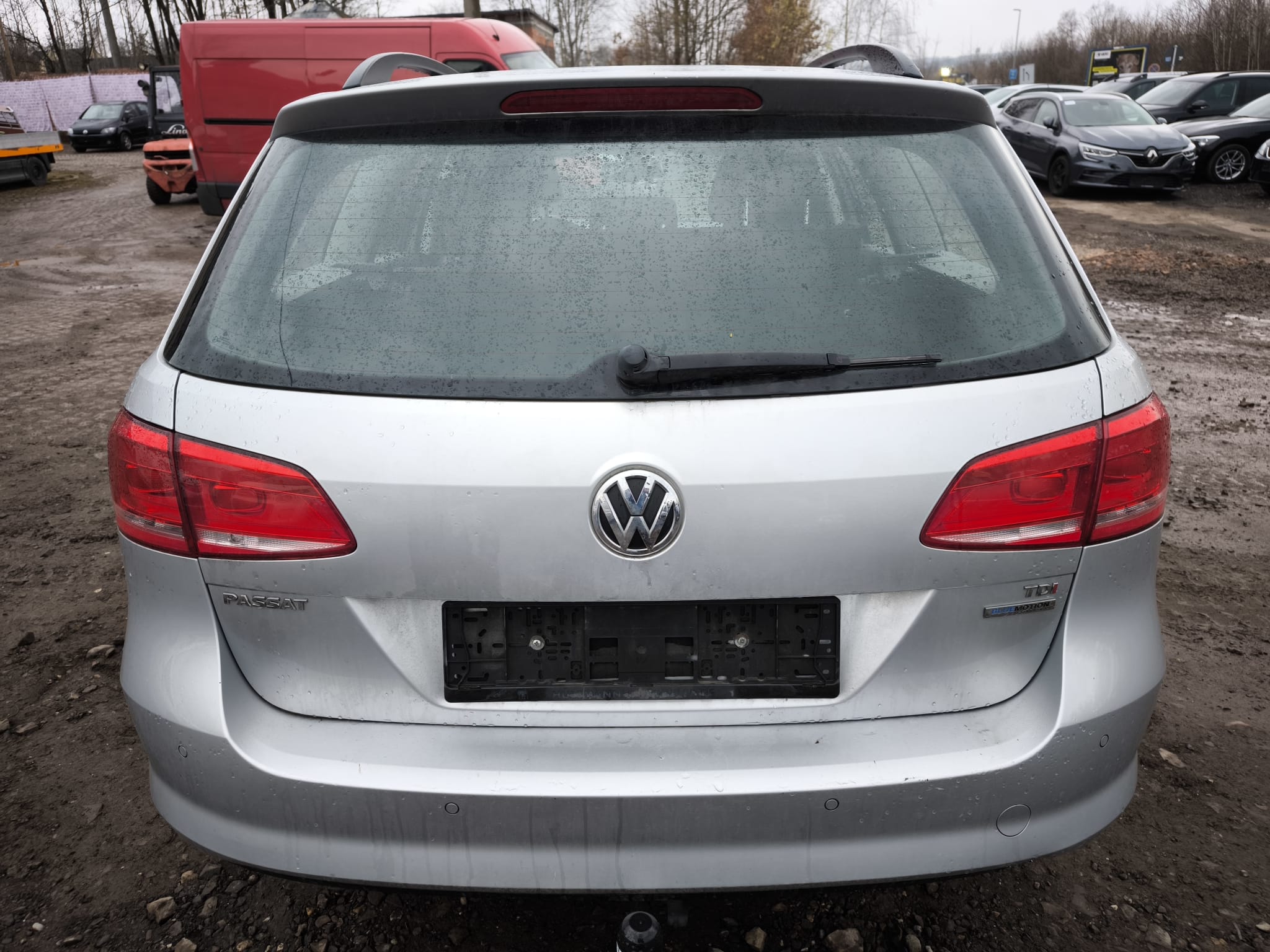 Rückansicht eines silbernen VW Passat Variant TDI auf schlammigem Parkplatz nach erfolgreichem Autoankauf in Berlin