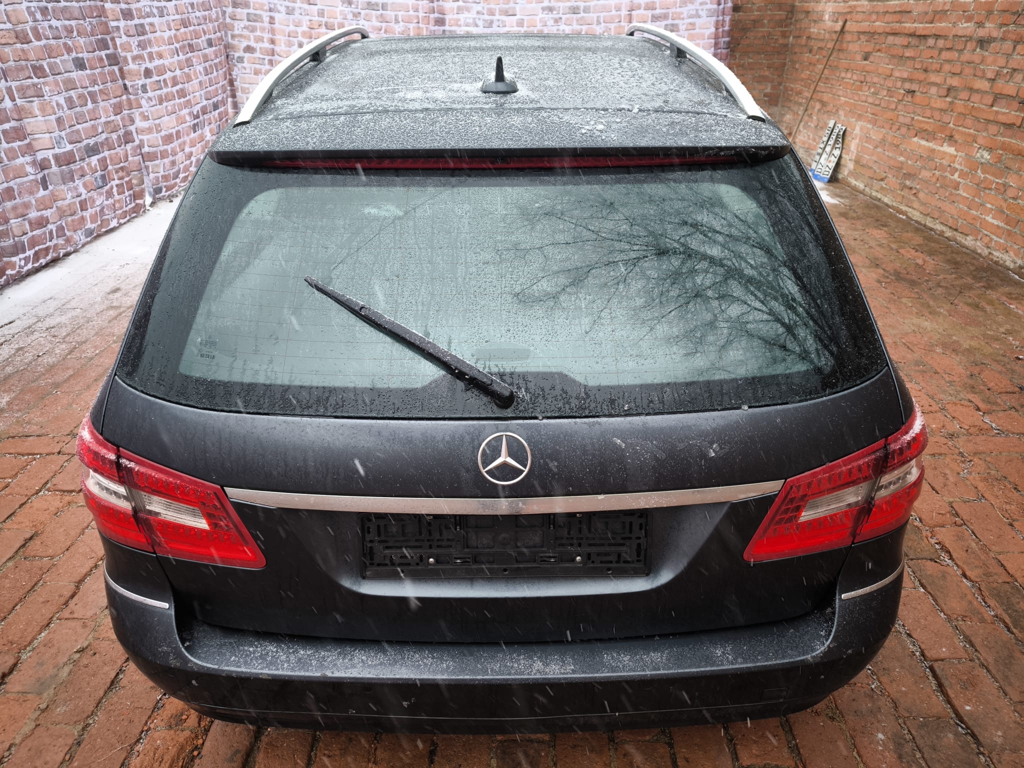 Mercedes Kombi mit nasser Heckscheibe nach dem Verkauf vor Backsteinmauer in Deggendorf zur Fahrzeugbewertung und zum Auto online verkaufen