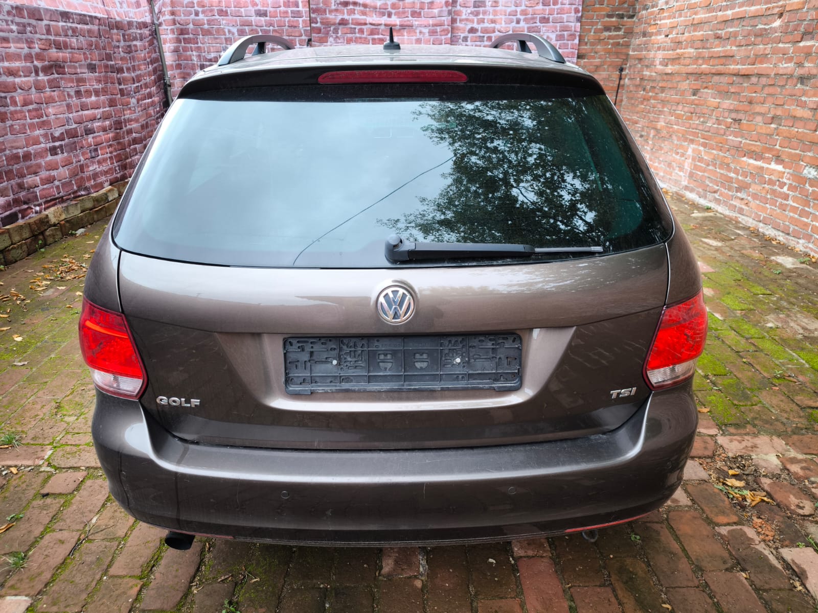 Volkswagen Golf TSI Kombi von hinten nach dem Verkaufen in Dreieich auf Hof mit Backsteinmauer
