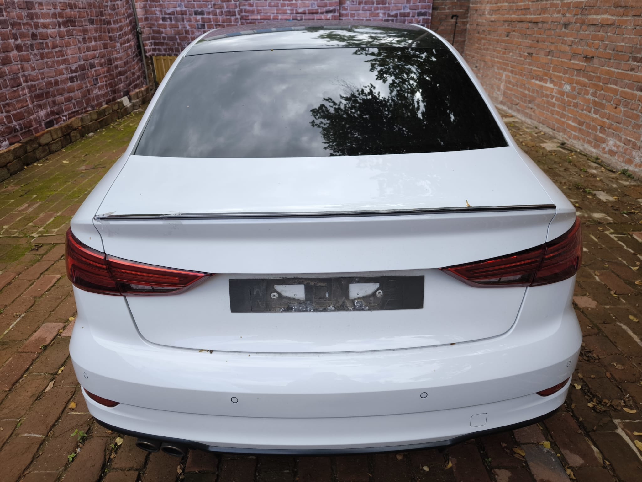 Weißer Audi Limousine von hinten in Hofeinfahrt bereits verkauft an Autoankäufer in Düsseldorf für seriösen Pkw Verkauf