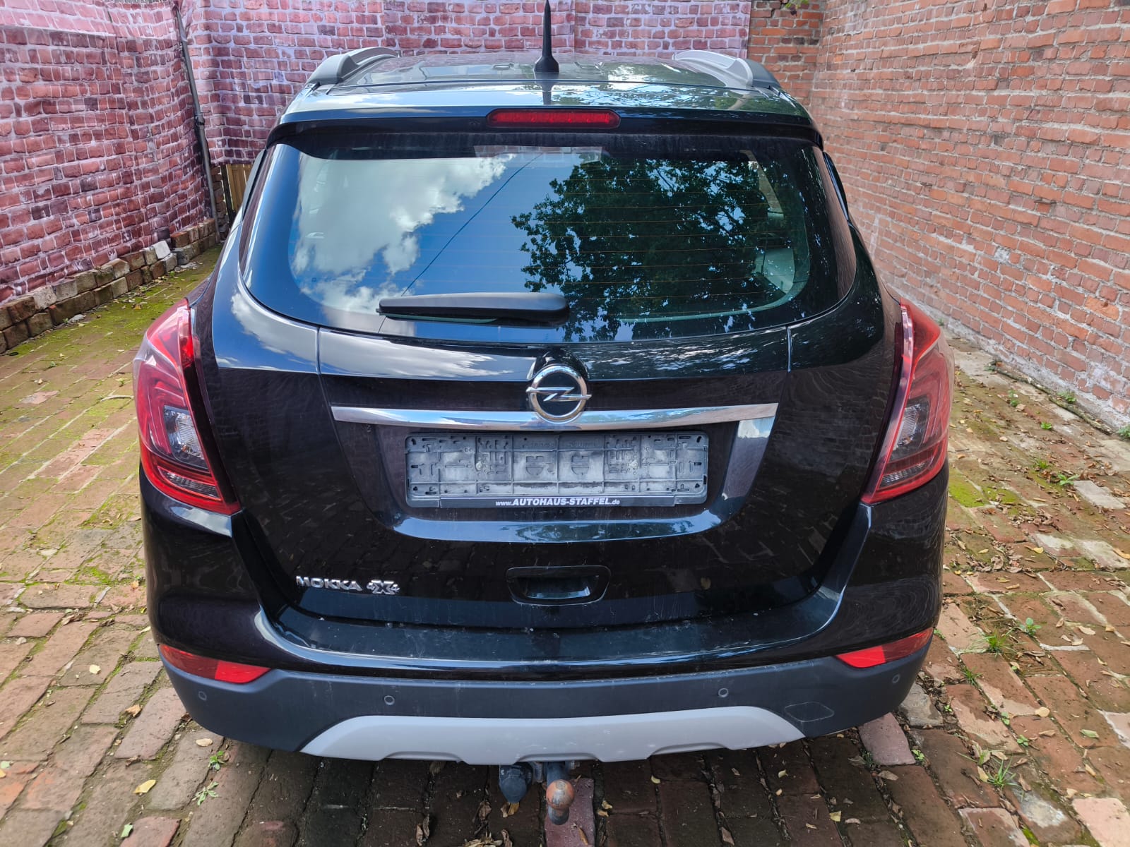 Opel Mokka X von hinten in Hofansicht als bereits verkaufter Wagen beim Auto verkaufen in Flensburg mit transparentem Ablauf