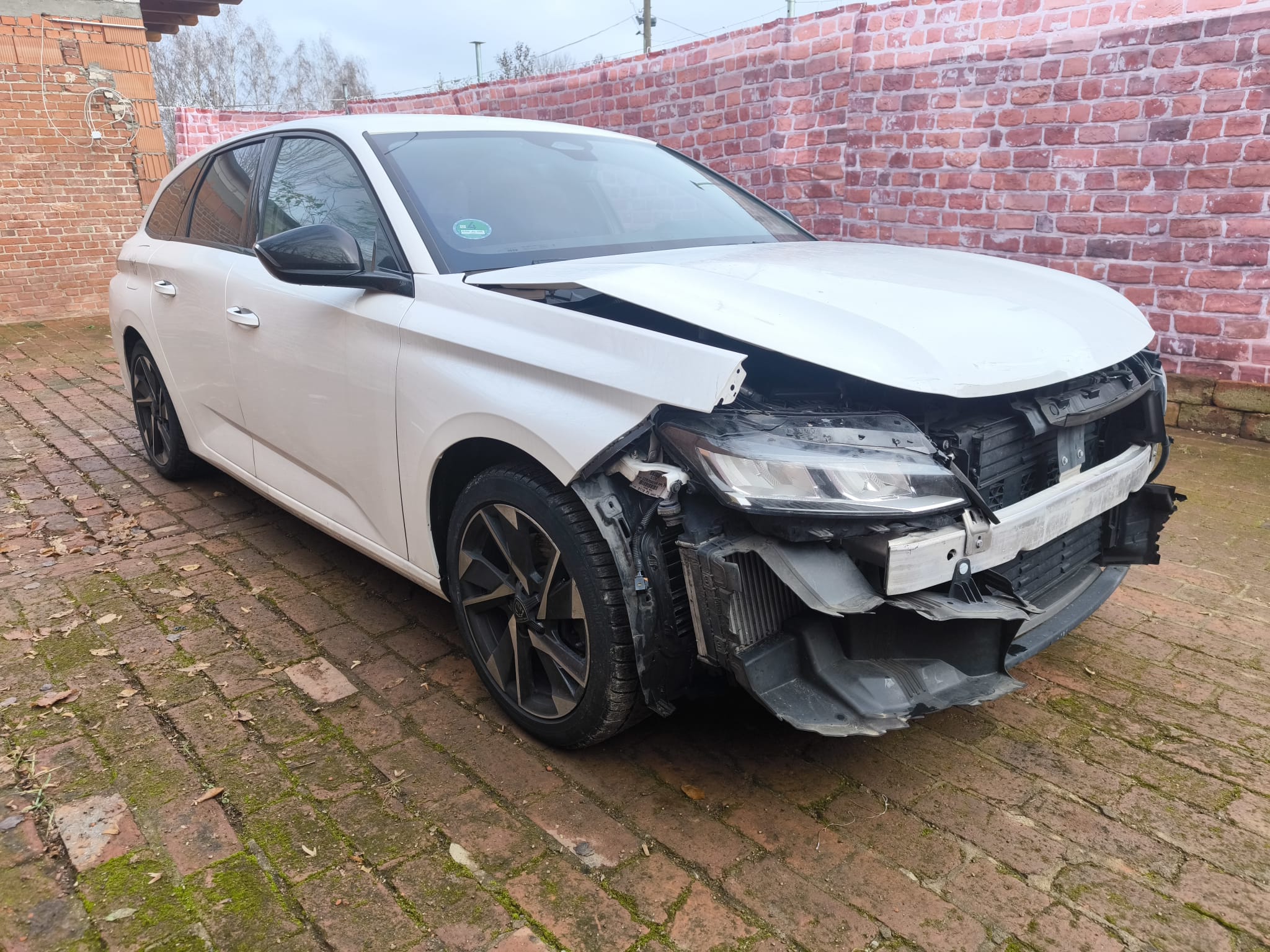 Weißer Peugeot 308 als Unfallauto mit Frontschaden auf Hof nach Verkauf in Flensburg