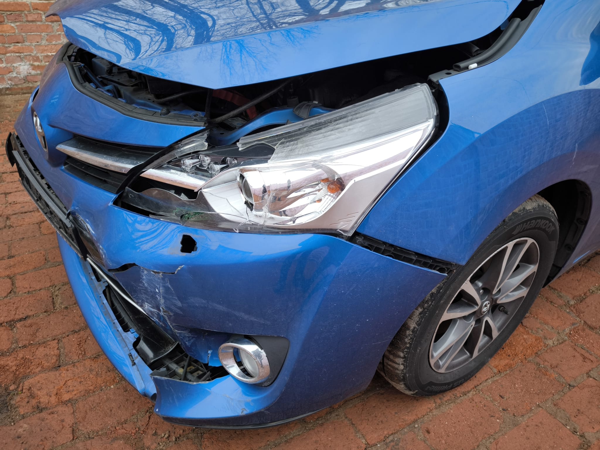 Beschädigter blauer Toyota mit starkem Frontschaden nach Unfall in Fürstenfeldbruck für direkten Autoverkauf