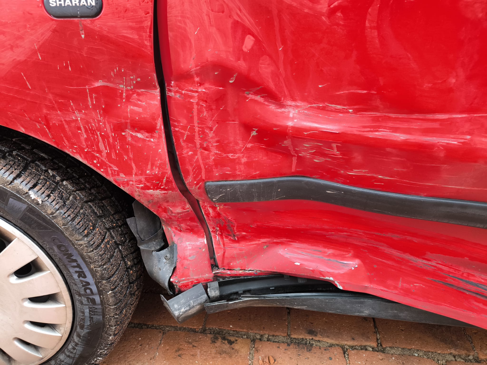 Seitenansicht eines roten VW Sharan mit starkem Unfallschaden an der Tür als Beispiel für Unfallwagen verkaufen in Halle (Saale)