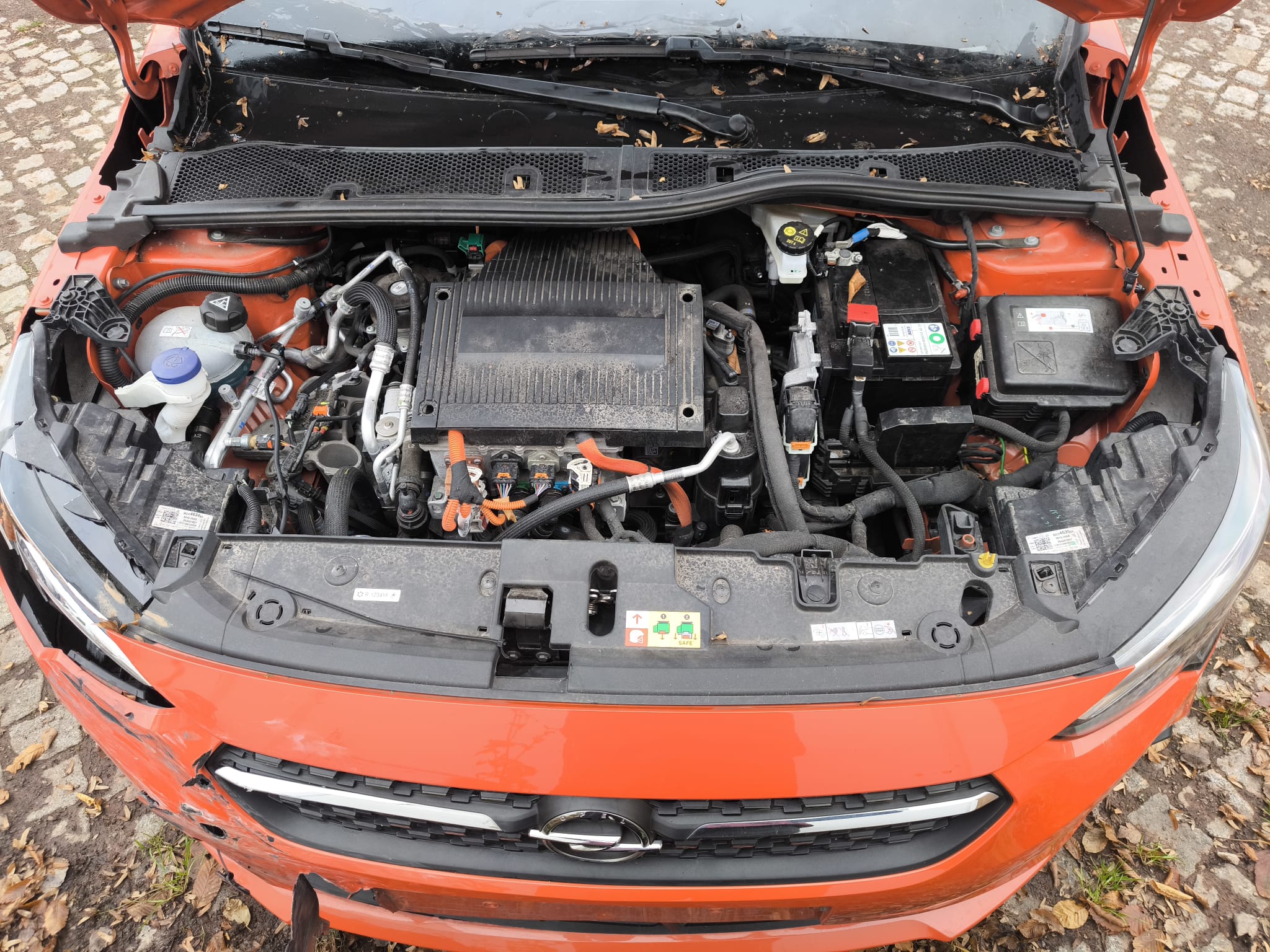 Beschädigter Motorraum eines orangefarbenen Opel Mokka nach Unfall, bereits verkauft und als Unfallwagen in Heidenheim an der Brenz verwertet