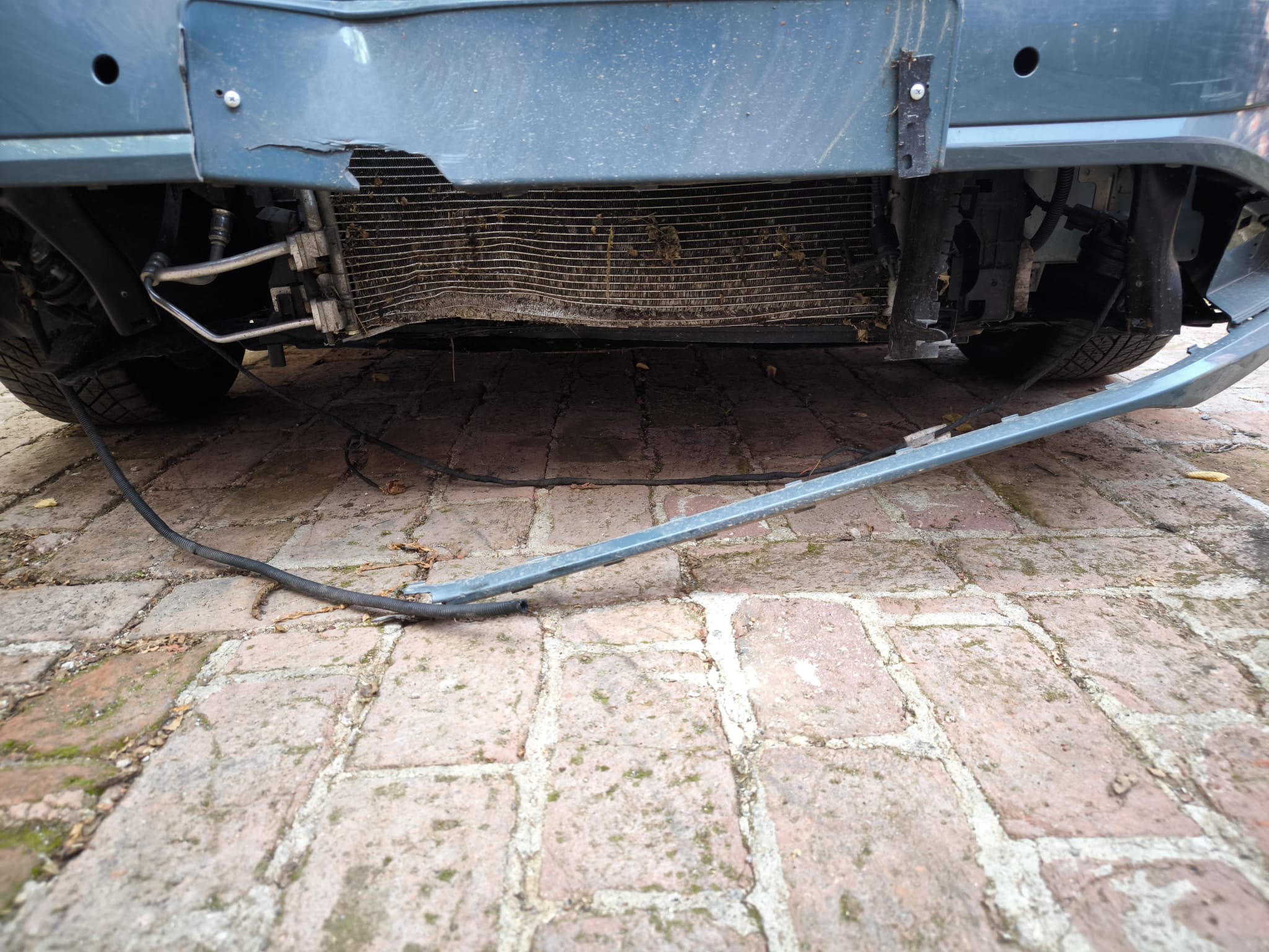 Stark beschädigte Front eines Unfallwagens mit herunterhängender Stoßstange und sichtbarem Kühler auf Hof in Herten verkaufen