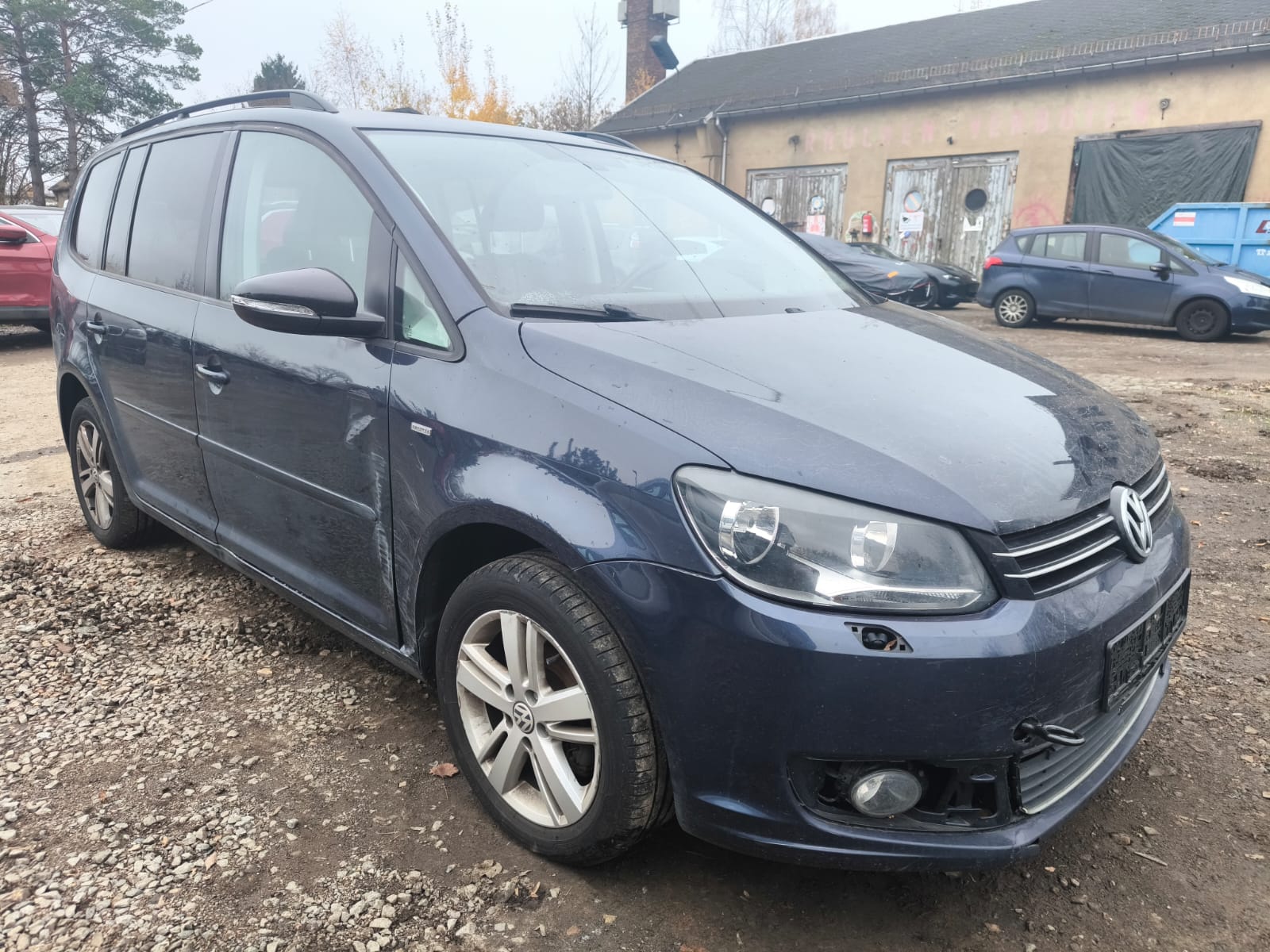 Beschädigter VW Touran auf Schotterplatz nach Verkauf an Autoaufkäufer in Leverkusen