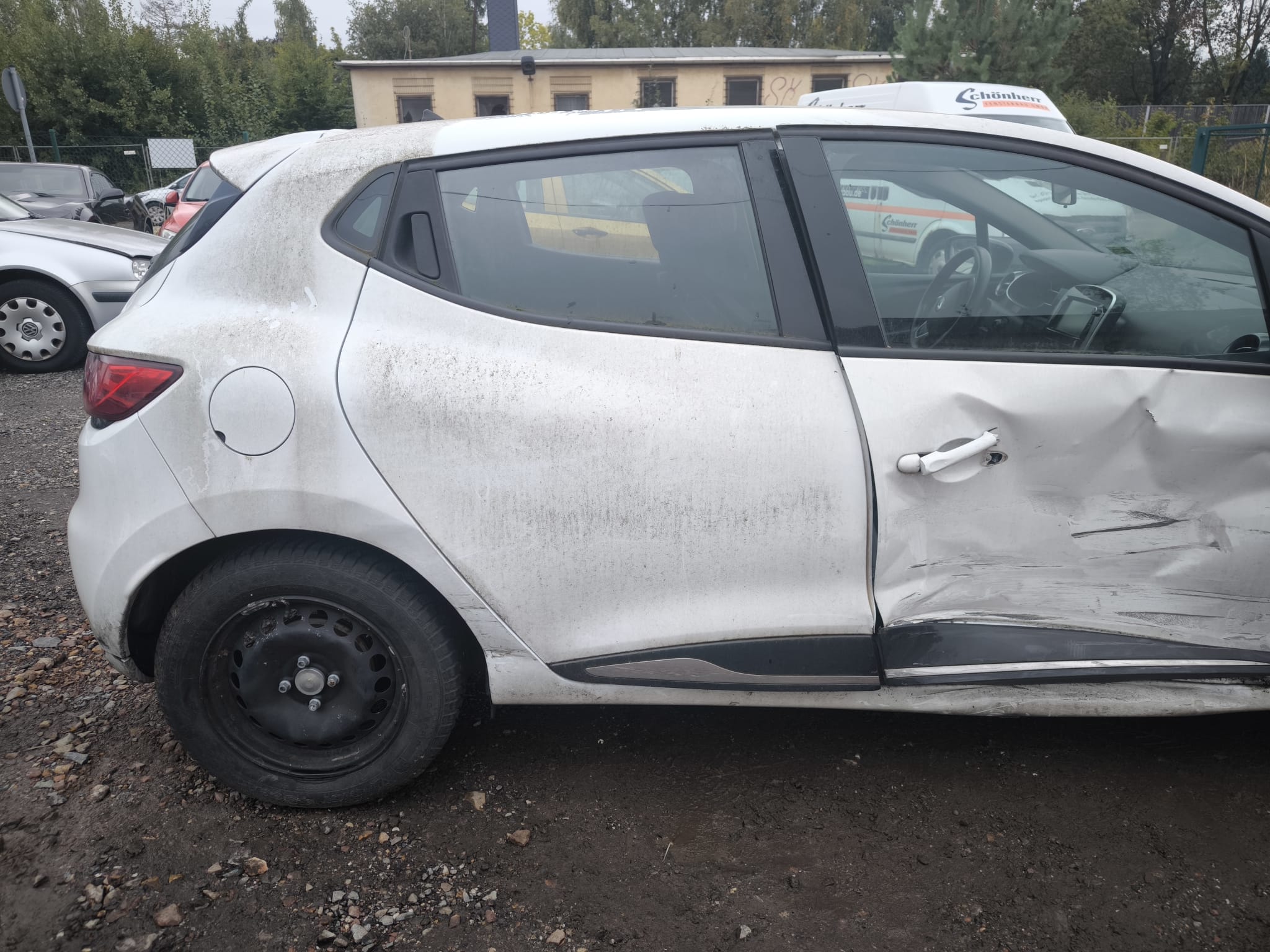 Seitenansicht eines stark beschädigten Renault Clio Unfallwagens auf einem Hof in Ludwigsburg zum Verkaufen