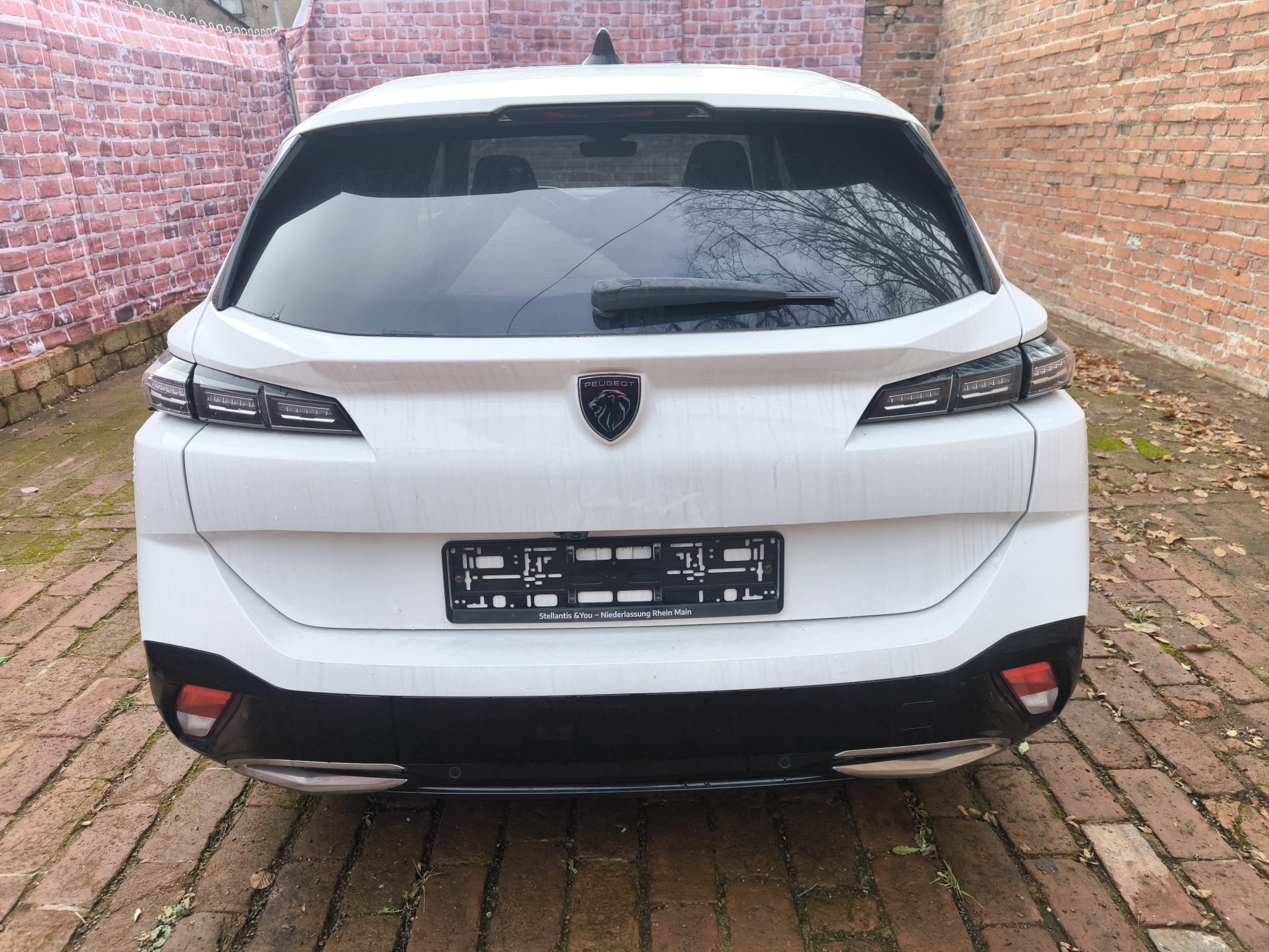 Weißer Peugeot 308 von hinten auf Hof nach Verkauf in Neumarkt in der Oberpfalz fotografiert, ideal um beschädigtes Auto online zu verkaufen