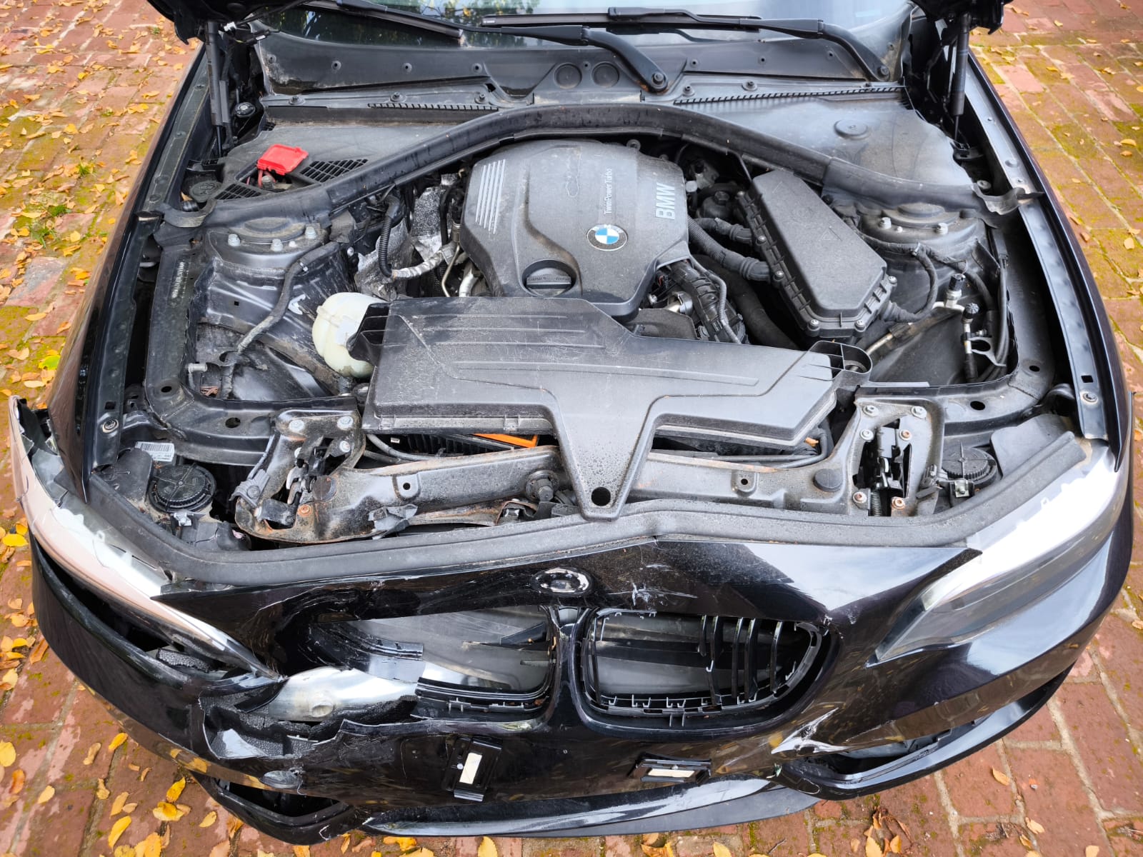 Beschädigter BMW mit starkem Frontschaden nach Unfall auf Hof in Neuwied zum Verkaufen an Unfallwagenhändler