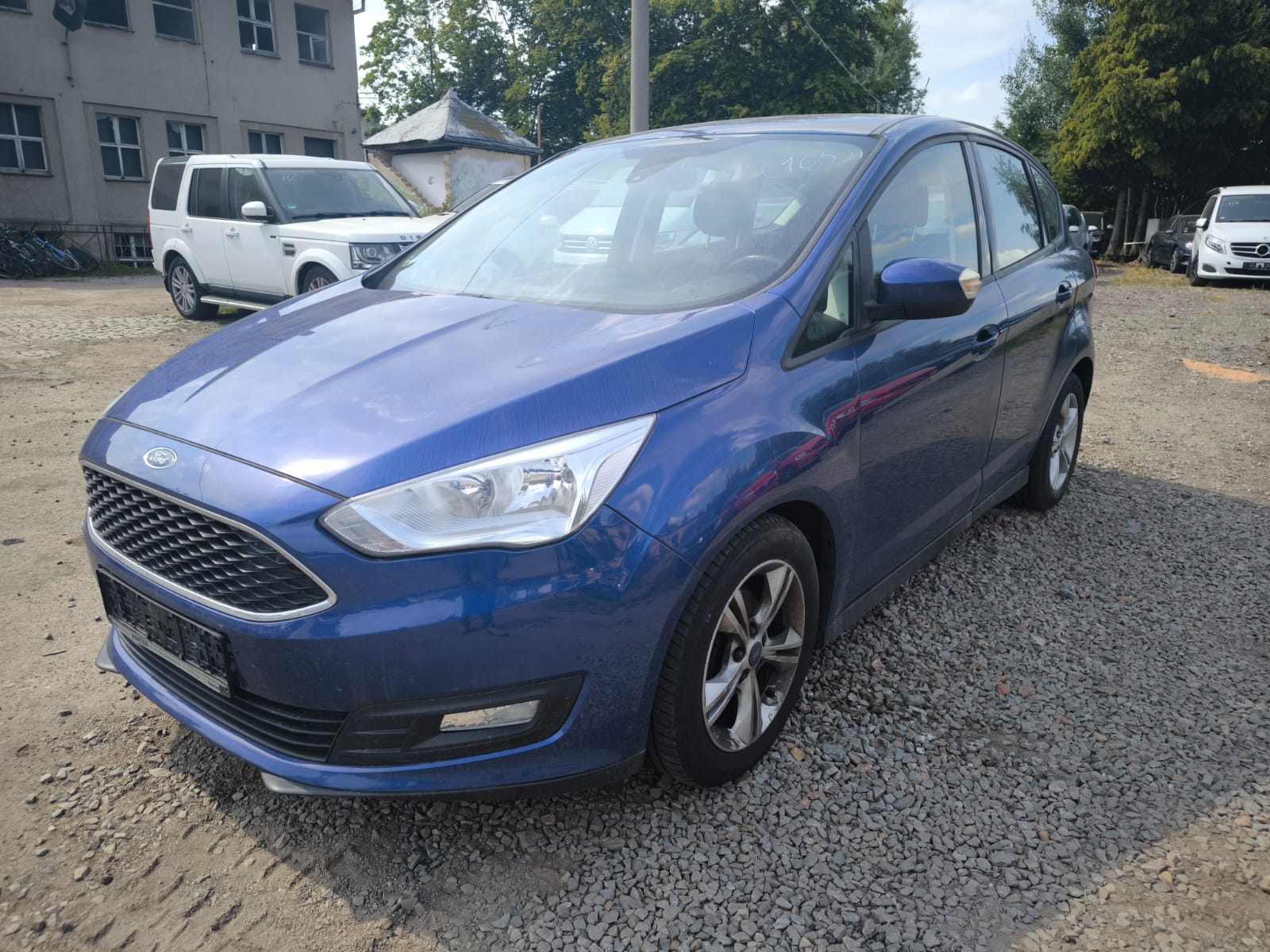 Blauer Ford C-Max als bereits verkaufter Unfallwagen auf Schotterplatz in Oberhausen verkaufen