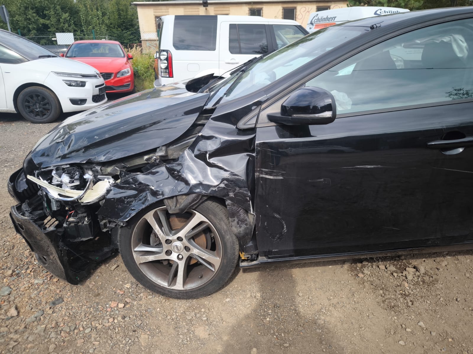 Schwarz beschädigter Volvo V40 nach Unfall auf Schotterplatz bereits verkauft in Olching weitergeben und Unfallauto ohne Reparatur verkaufen