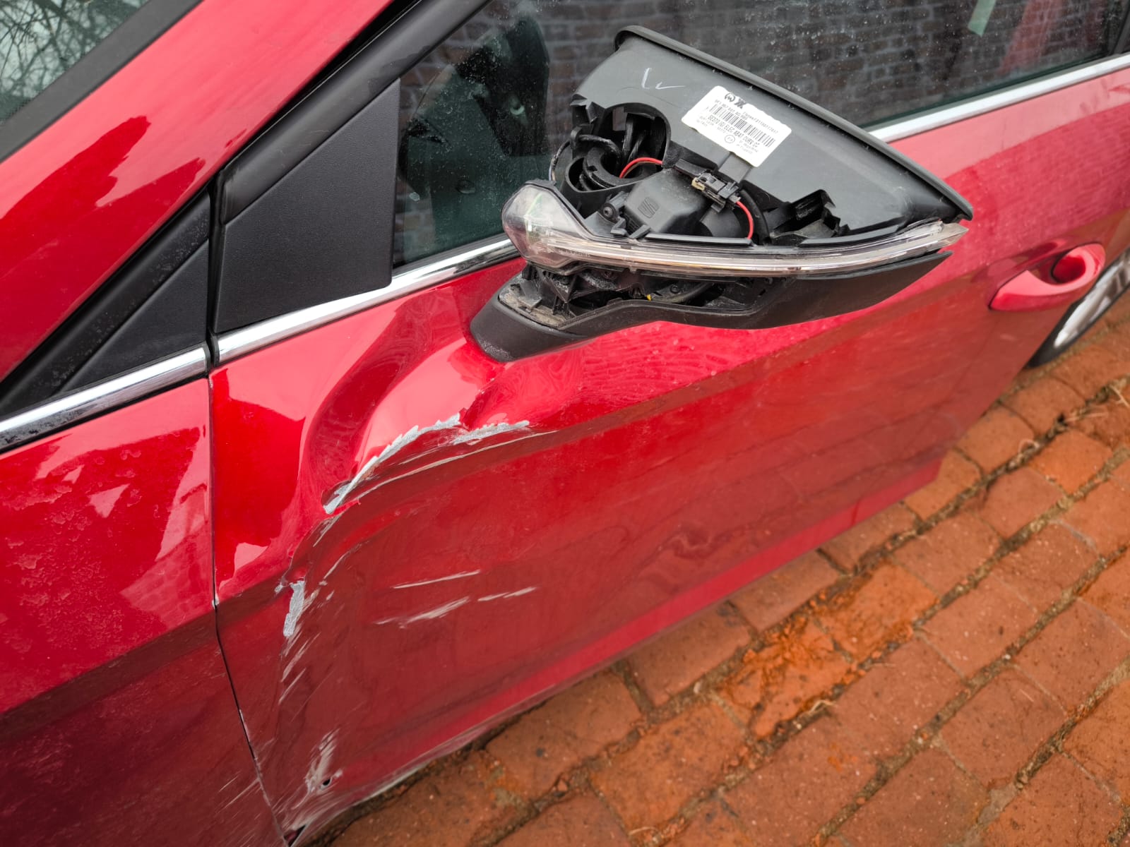 Rotes Auto mit stark zerkratzter Fahrertür und beschädigtem Außenspiegel nach Unfall in Osnabrück verkaufen