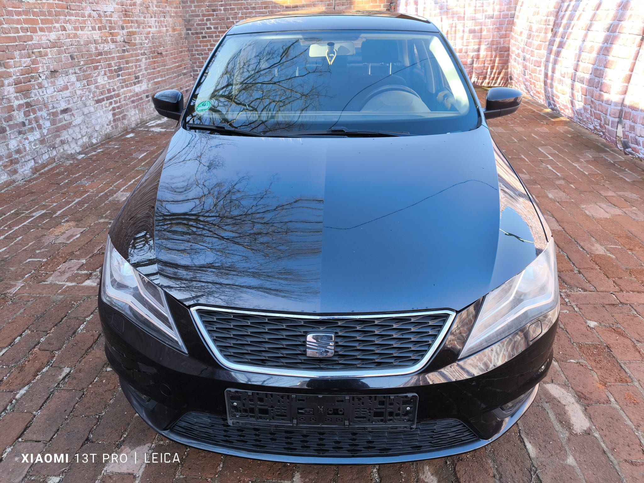 Schwarzen Seat in Rosenheim mit Getriebeschaden verkaufen Vorderansicht auf gepflastertem Hof