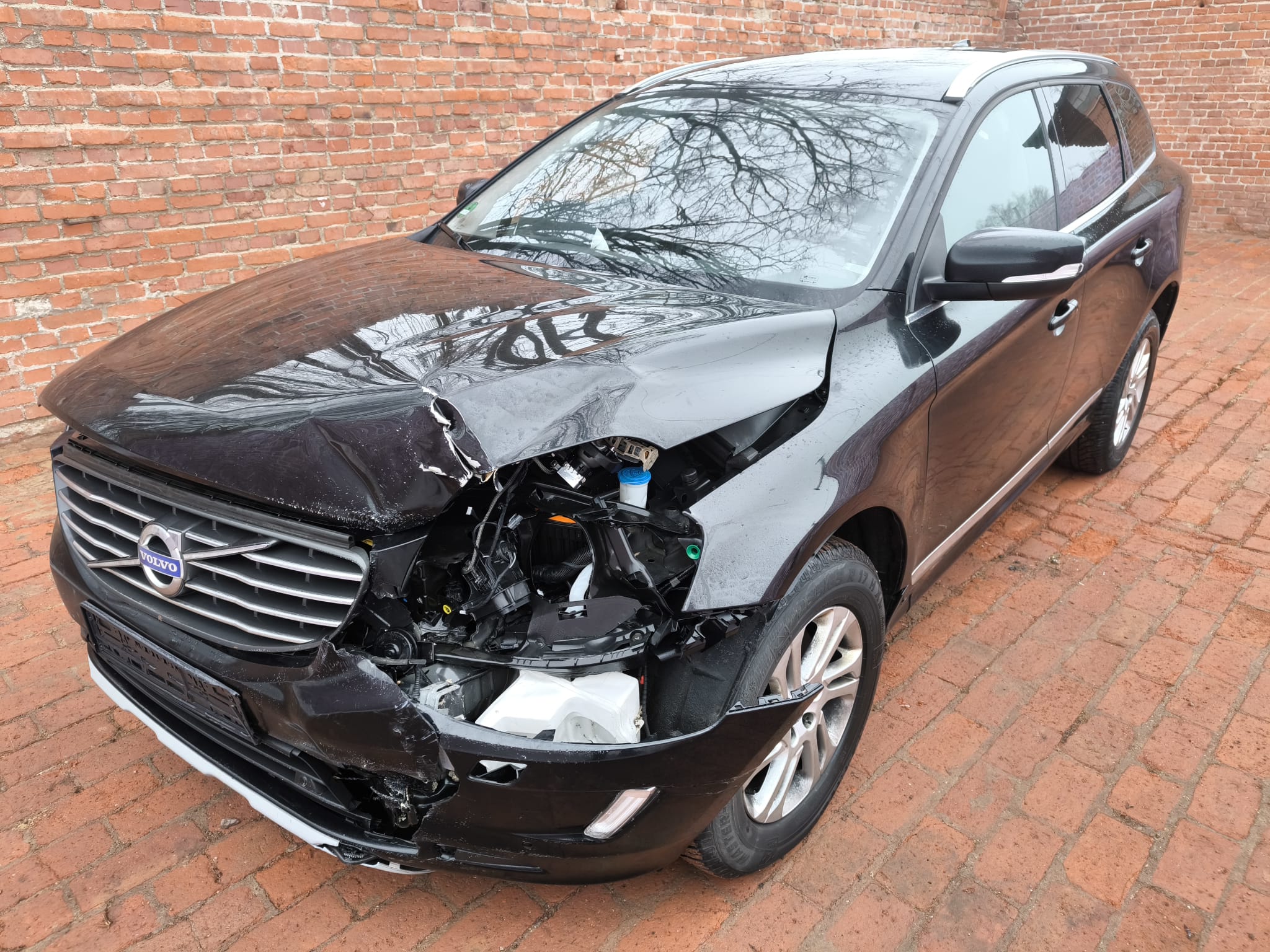 Beschädigter Volvo SUV als Unfallauto vor einer Backsteinmauer nach erfolgreichem Auto Verkauf in Unna