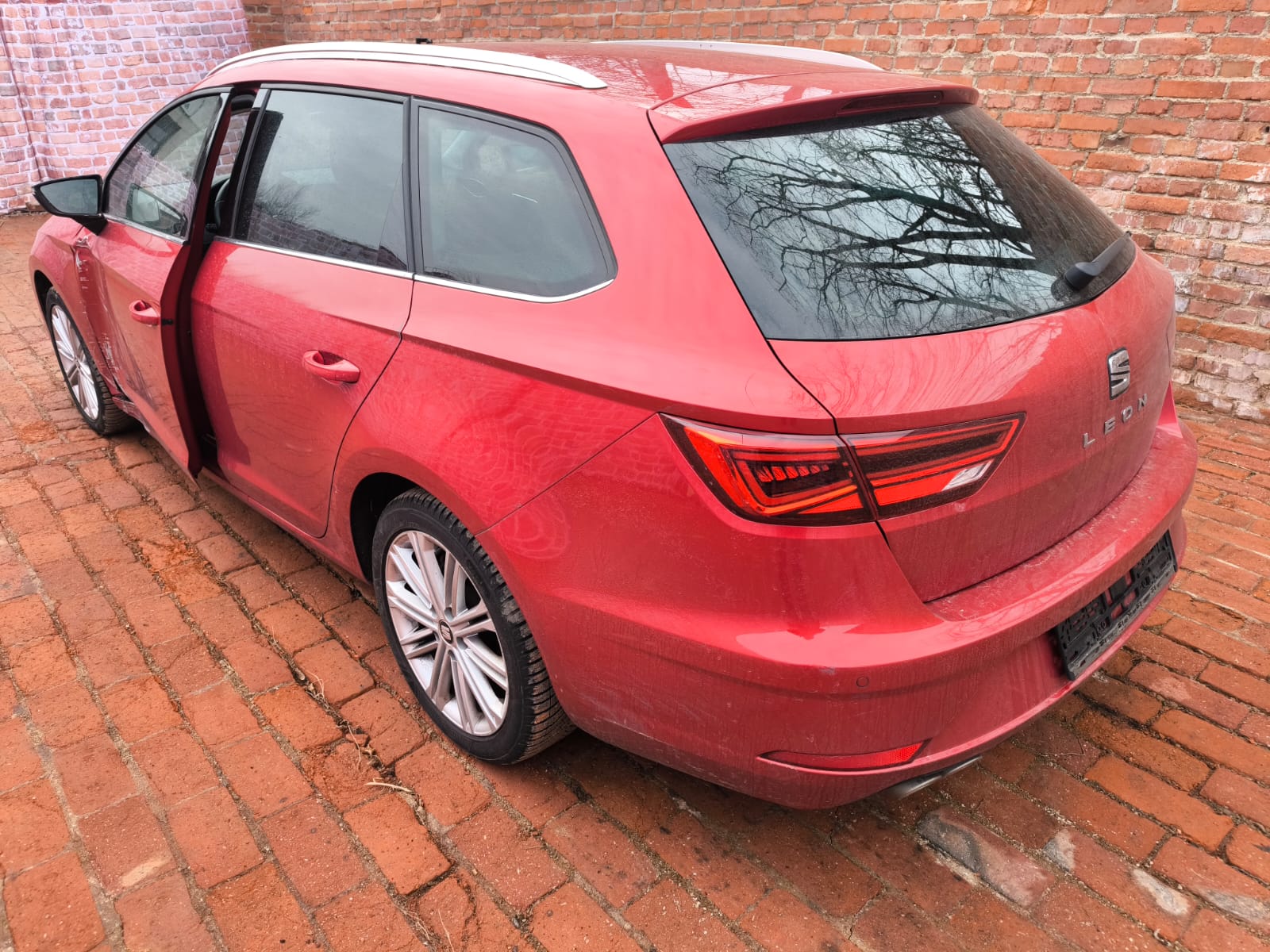 Roter Seat Leon Kombi mit Seitenschaden auf Hof nach dem Verkaufen in Wesseling zur Wertermittlung des Autos