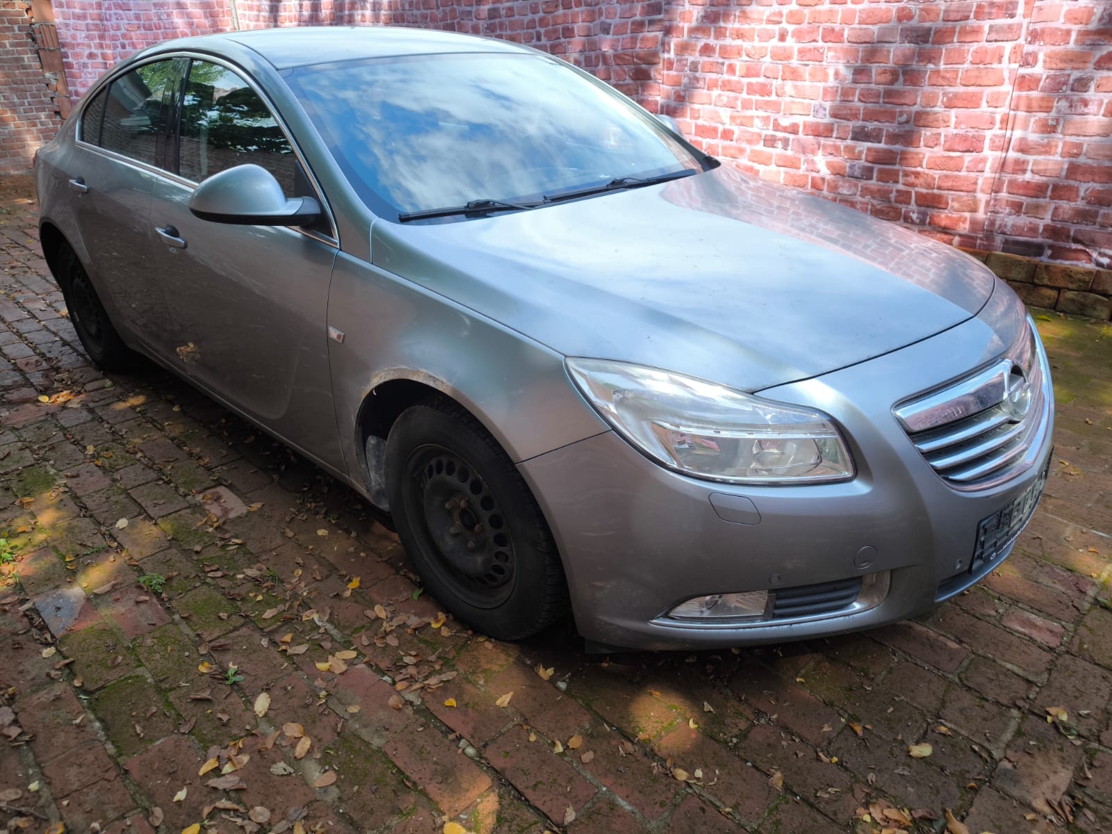 Silberner Opel Insignia mit Gebrauchsspuren auf Hof nach erfolgreichem Autoverkauf in Wiesbaden