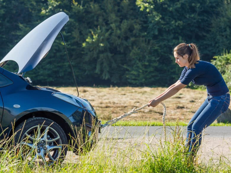 Frau schleppt Auto mit der Hand ab