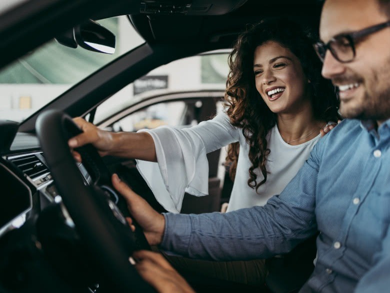 Paar beim PKW-Verkauf im Auto