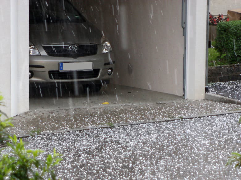 Auto steht in der Garage beim Hagel als Schutz vor dem Schaden