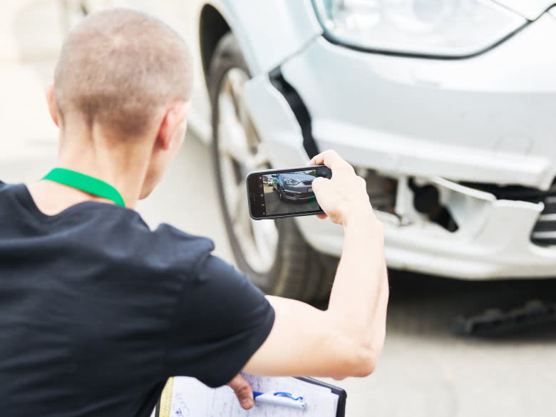 Gutachter fotografiert den Schaden am Unfallwagen
