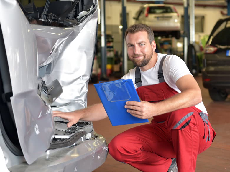 Mechaniker bewertet den Heckschaden für eine Reparatur