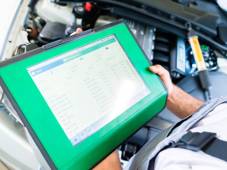 Gutachter führt Motoranalyse am Tablet für das Motorschaden Gutachten durch